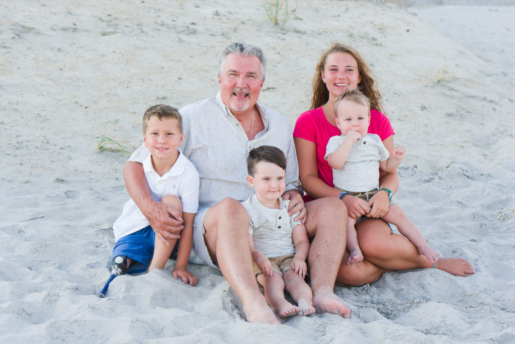 grandfather with grandchildren on beach