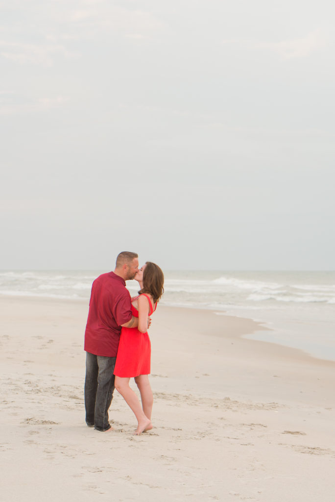 couple kissing while walking on the beach