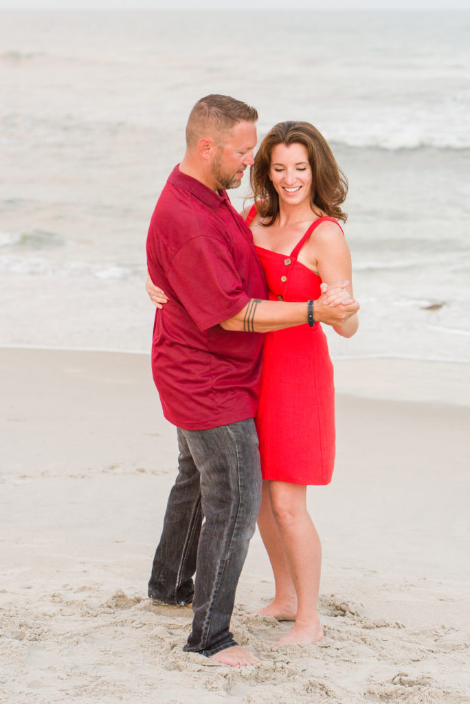 husband and wife dancing on beach