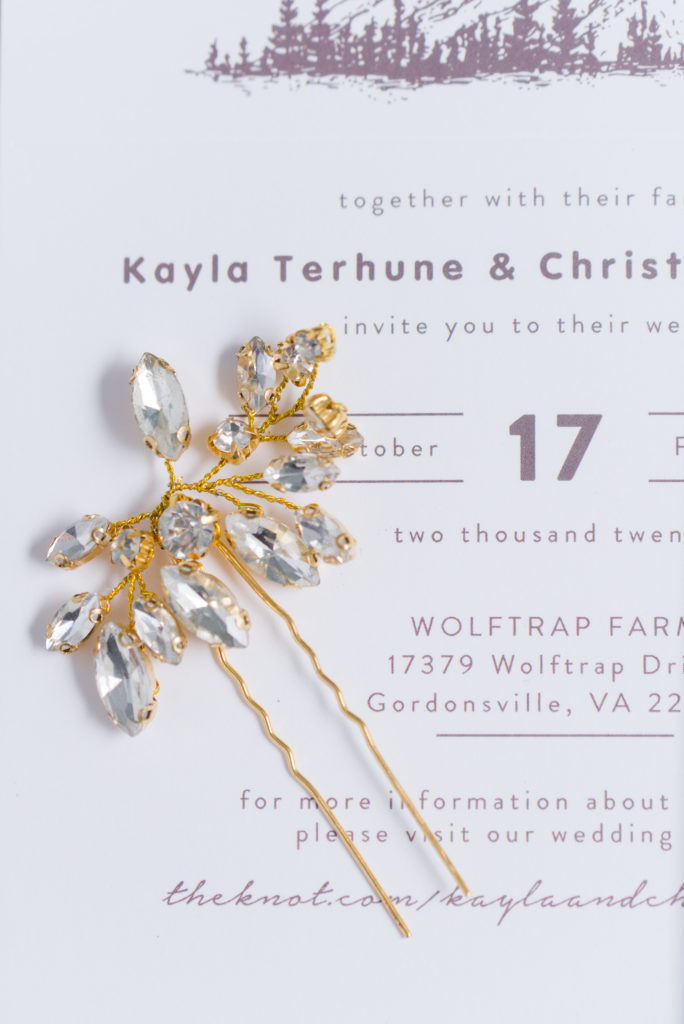 wedding invitation with gold accented hair pin

