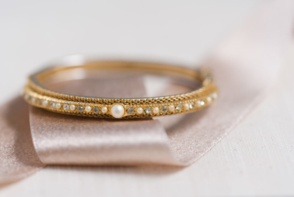 gold bracelet on champagne colored ribbon