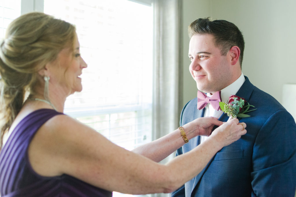 mother of groom pinning on boutonnière