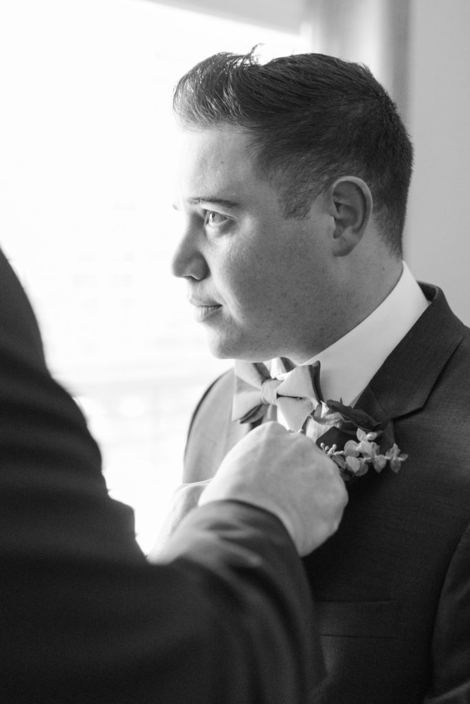 father of the groom adjusting boutonnière