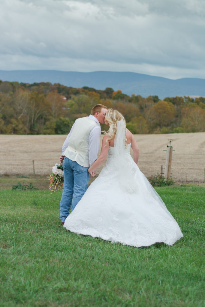 bride and groom kissing in mountain backdrop