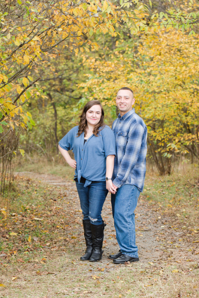 portrait of Couple holding hands in fall foliage