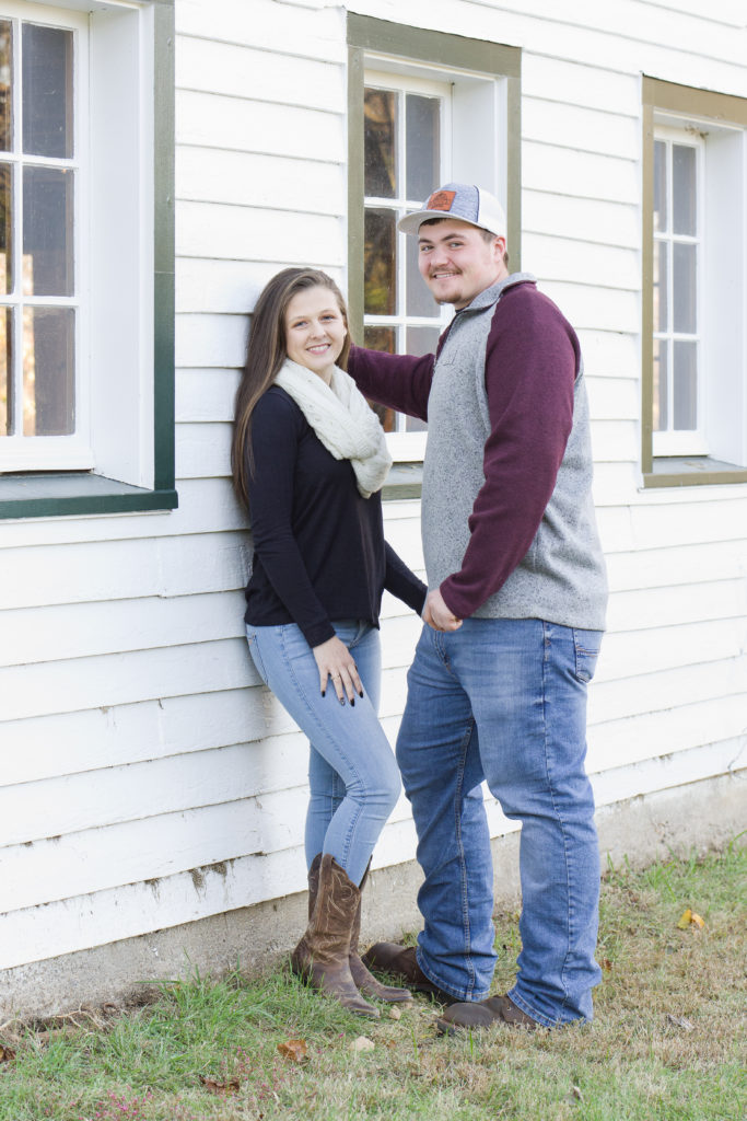 engaged couple standing beside barn at Ivy Creek Natural Area