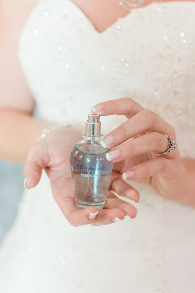 bride holding perfume bottle