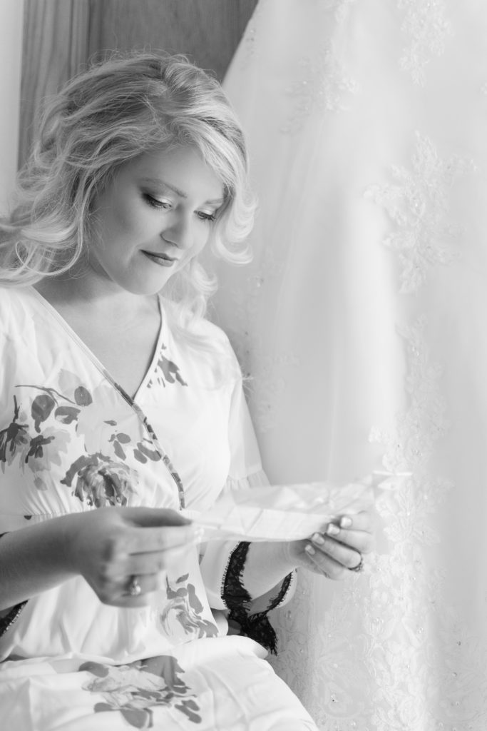photo of bride reading note from groom before wedding