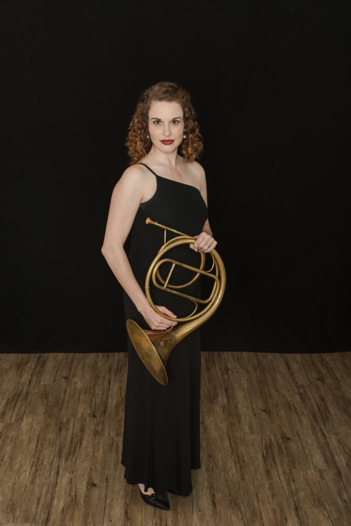 female natural horn player in black dress