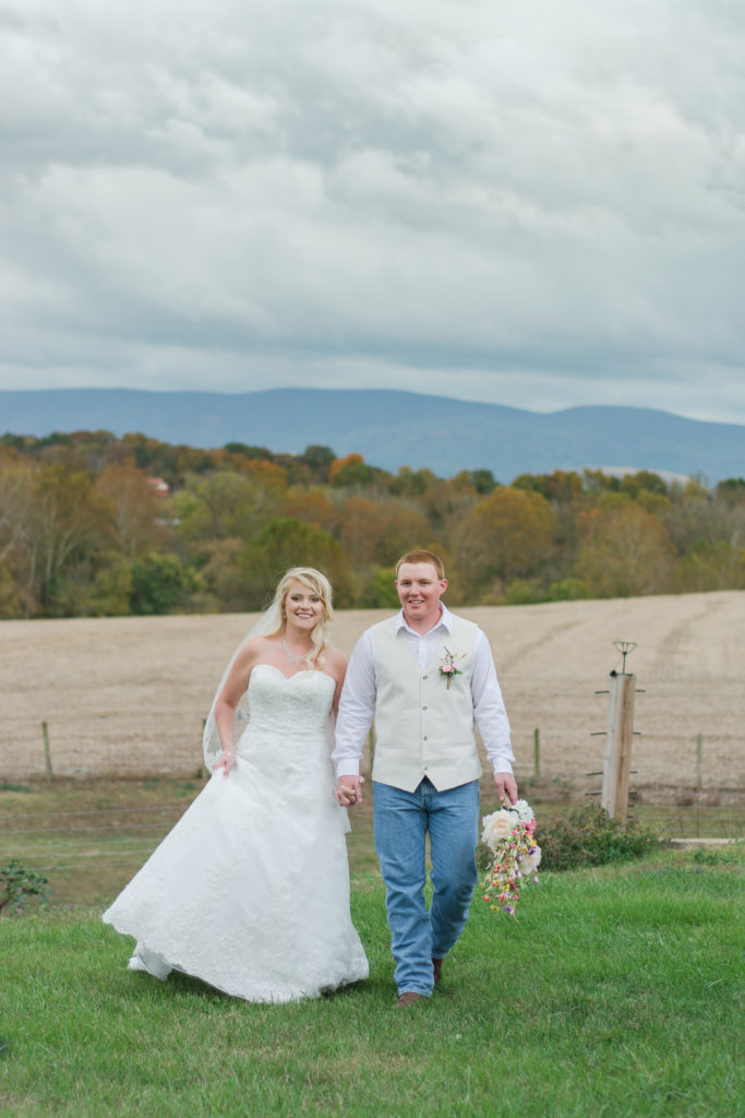 bride and groom walking with mountain view at rustic wedding venue