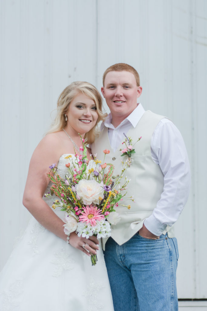 bride and groom in front of rustic barn at Rivercrest Farm Elkton Virginia