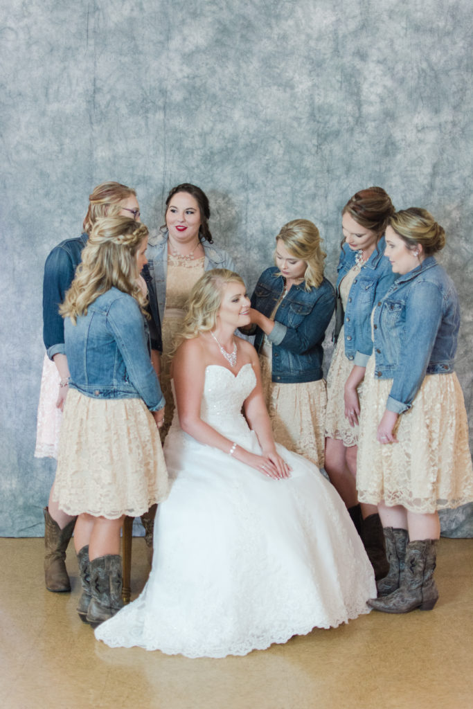 bridesmaids helping bride with earrings
