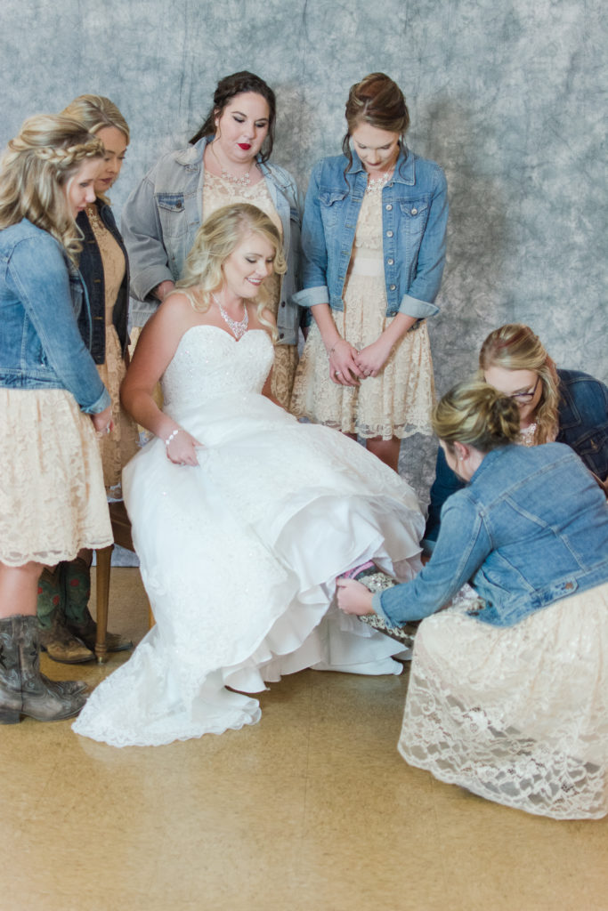 bridesmaids helping bride get dressed