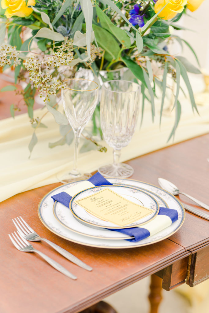 place setting for blue and yellow themed reception table