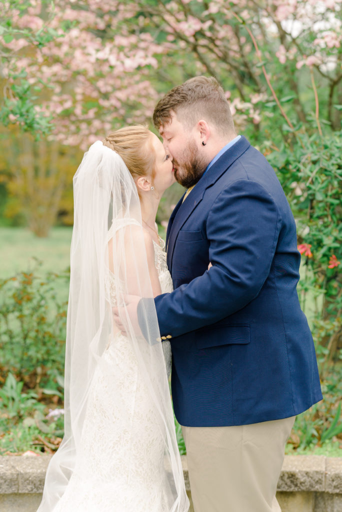 bride and groom kissing for romantic portraits