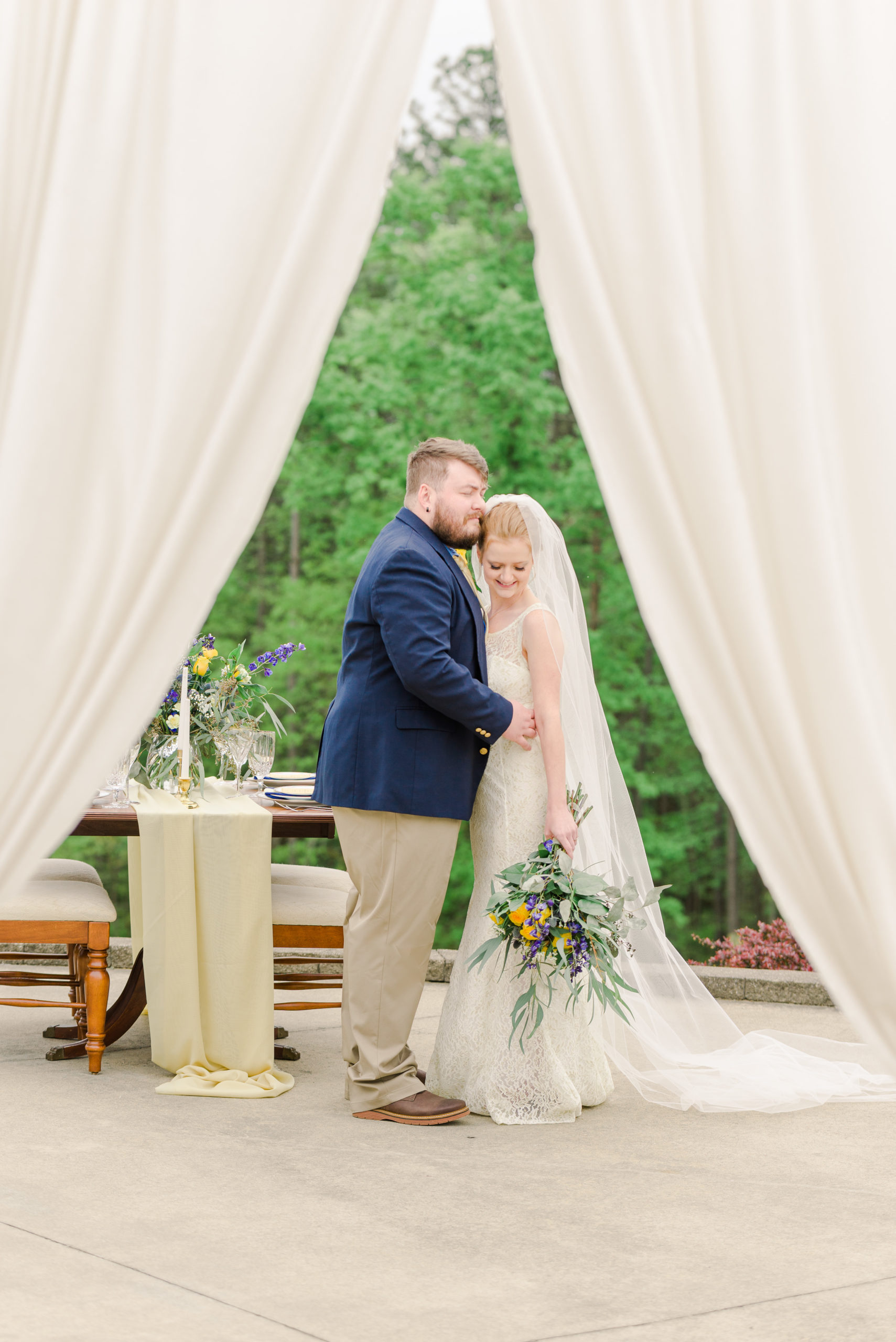bride and groom standing in front of sweetheart table for styled shoot