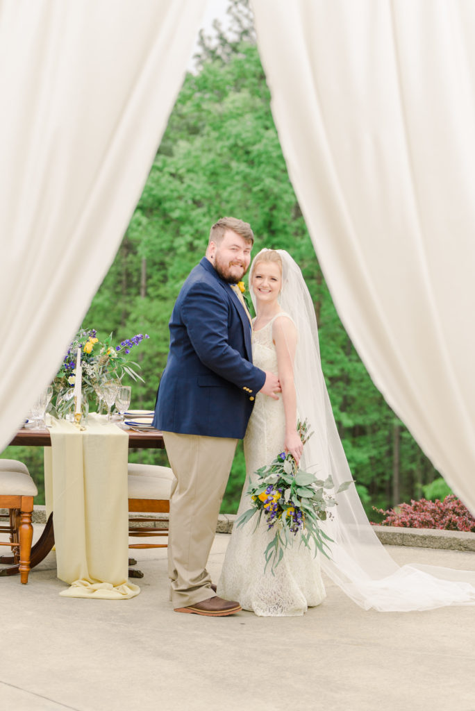 groom and bride in front of blue and yellow themed sweetheart table