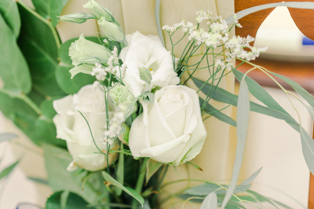 white roses for bride's chair decor