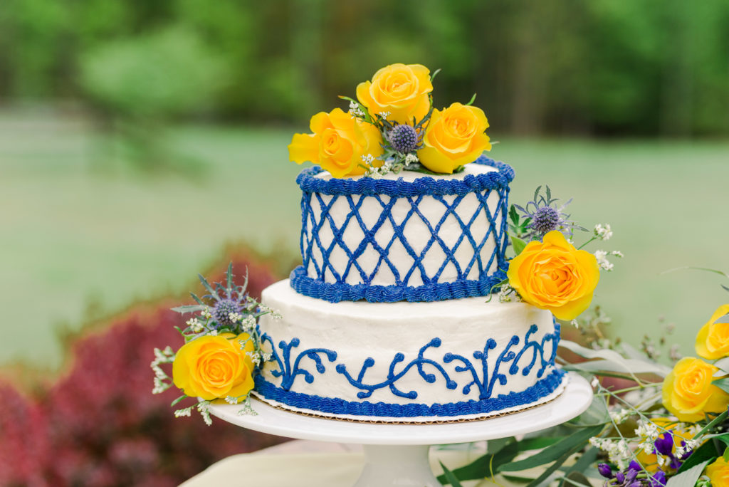 blue and white wedding cake with yellow roses