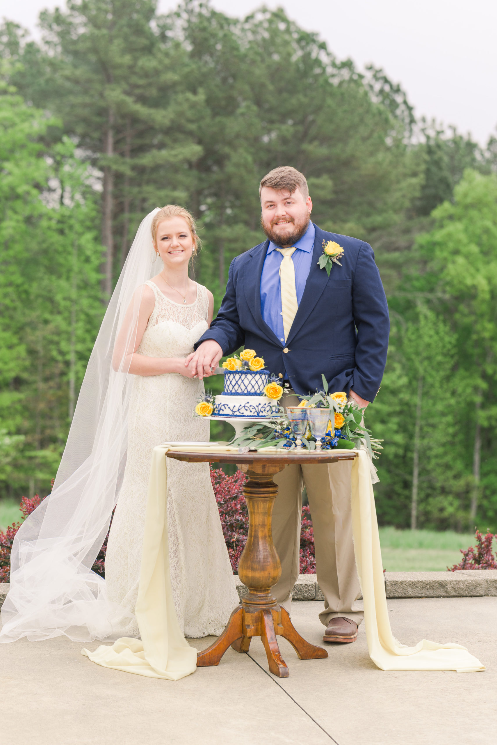 Bride and groom getting ready to cut wedding cake for styled shoot - Blue and yellow color scheme