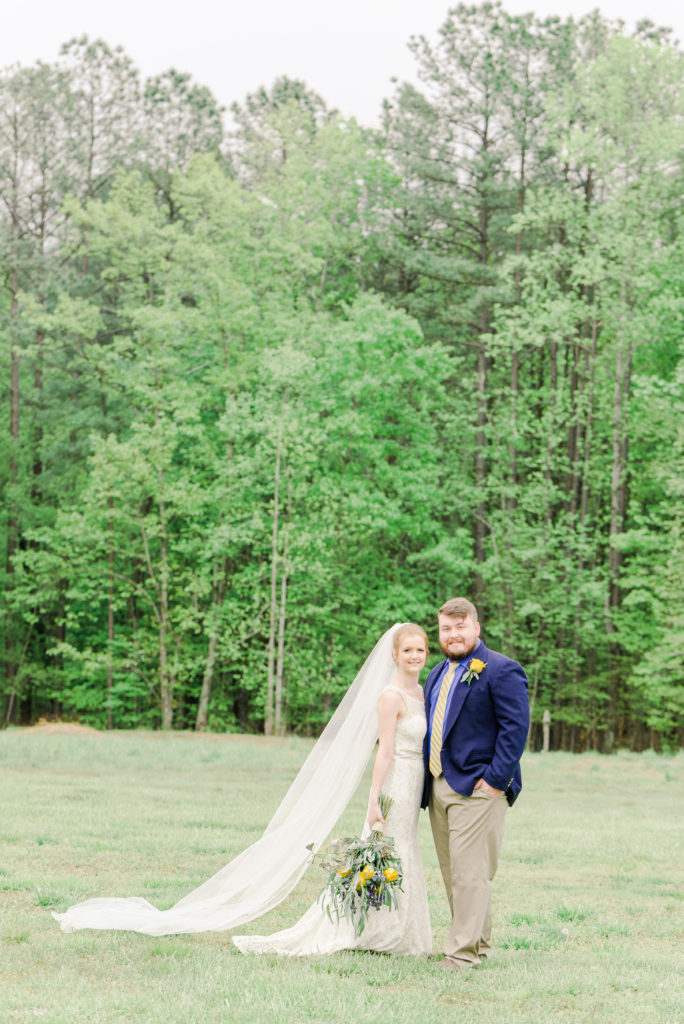 bride and groom posing in open field