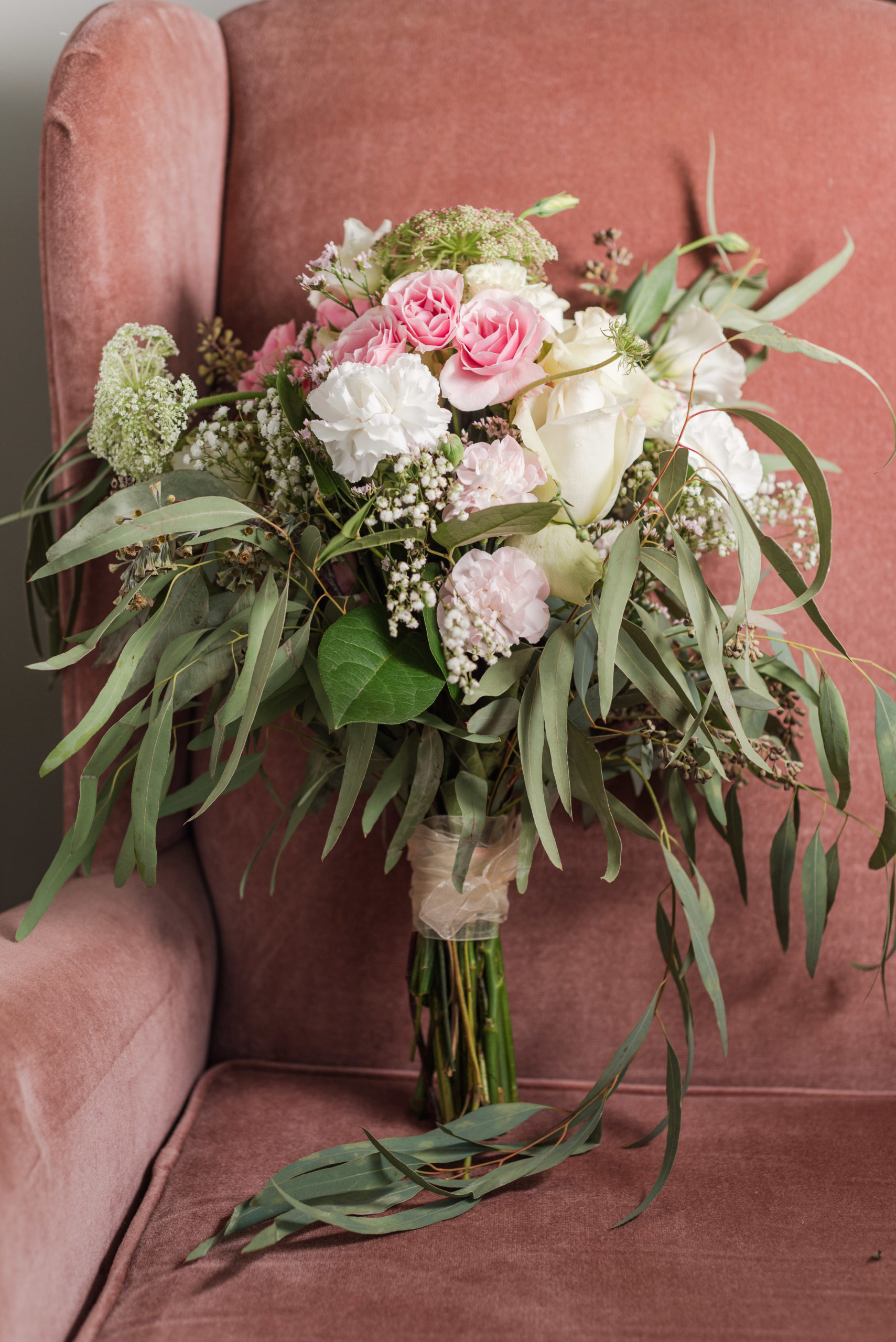 pink, white and green wedding bouquet standing in chair