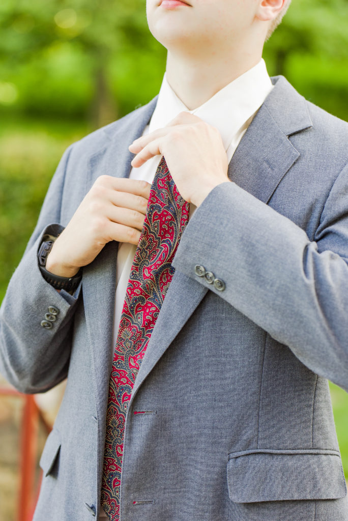 senior adjusting suit tie