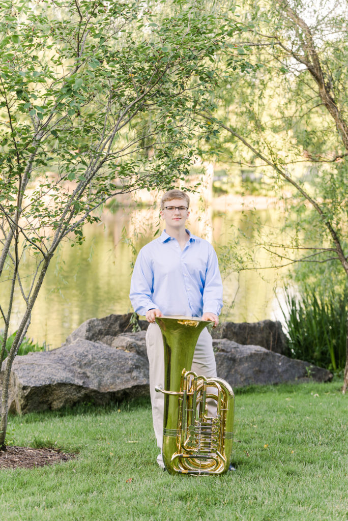 Senior portrait lakefront with tuba