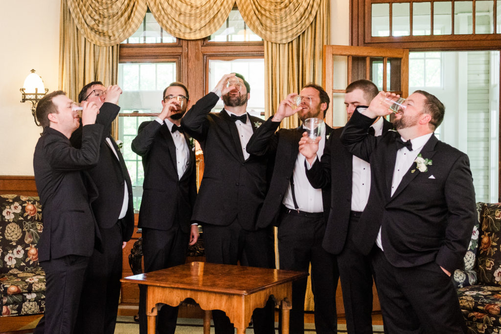 groom and groomsmen share a drink before the ceremony
