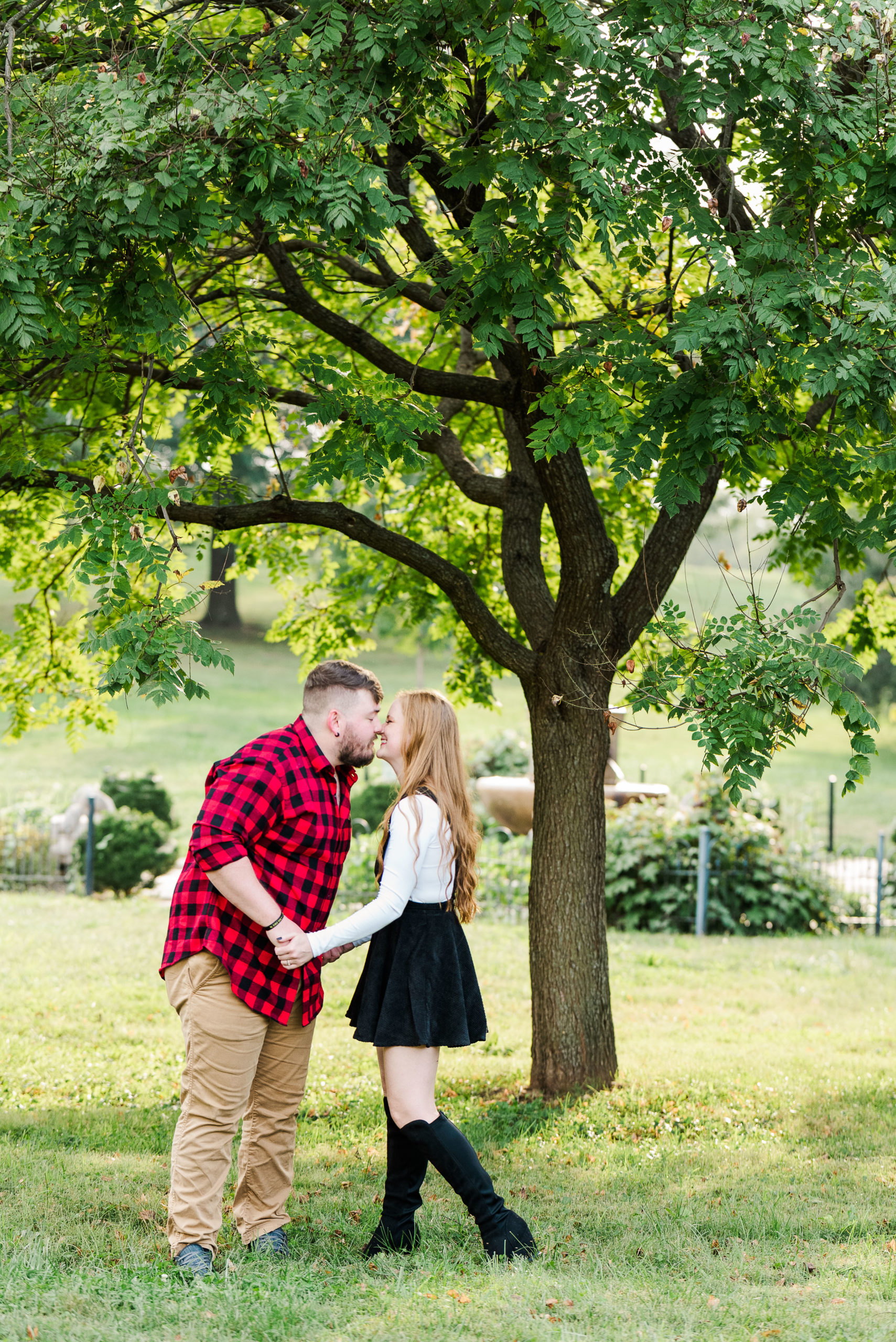 couple kissing under tree in park