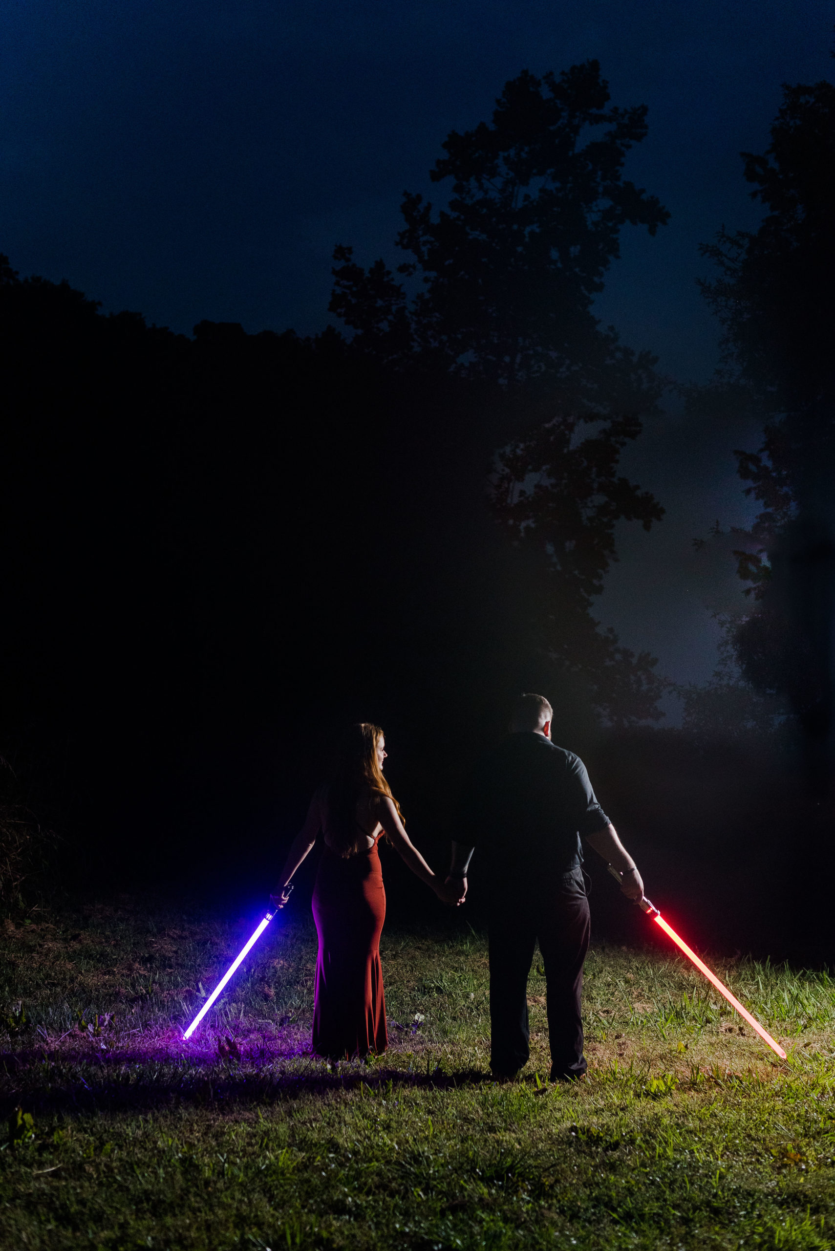 Wendi and Sage's Engagement Session carrying lightsabers after dark