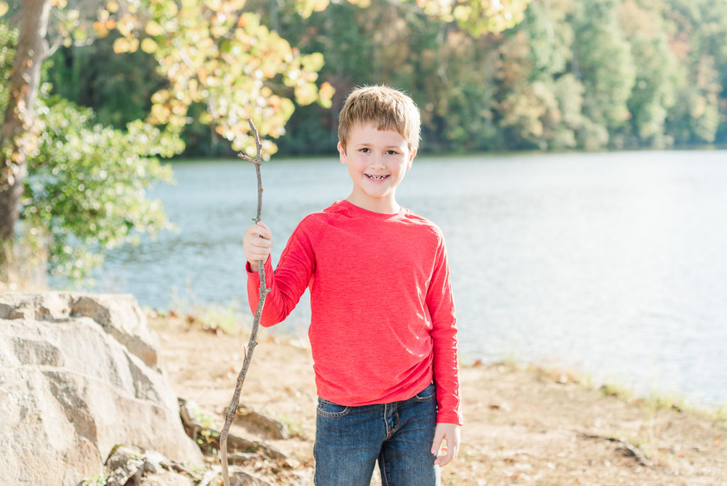 child holding stick on lake  - James' 8th Birthday