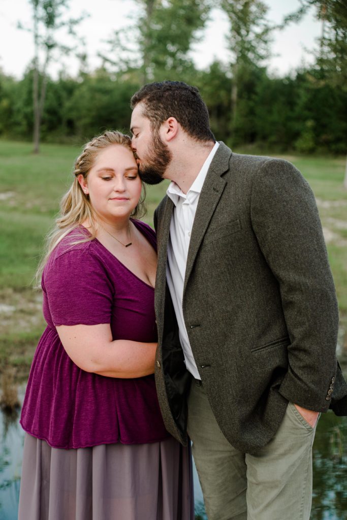 groom to be kissing bride to be during engagement session