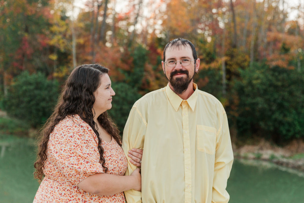 engagement session portrait with water and fall foliage