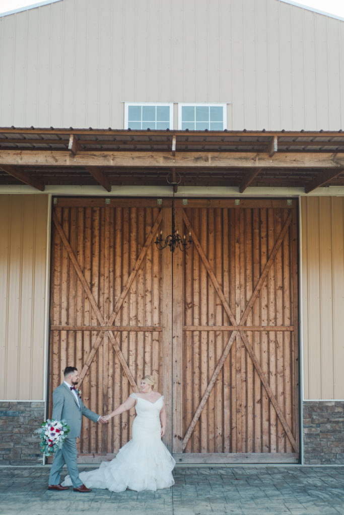 couple walking in front of barn during couple portraits before wedding