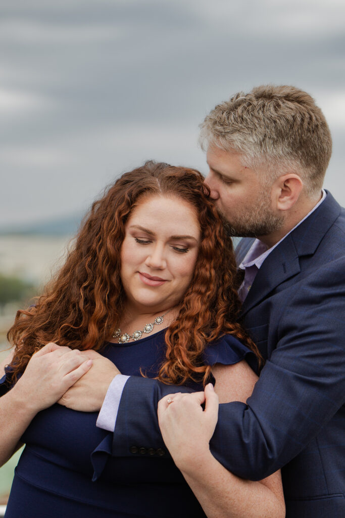 couple embracing Engagement Session at Center in the Square Rooftop
