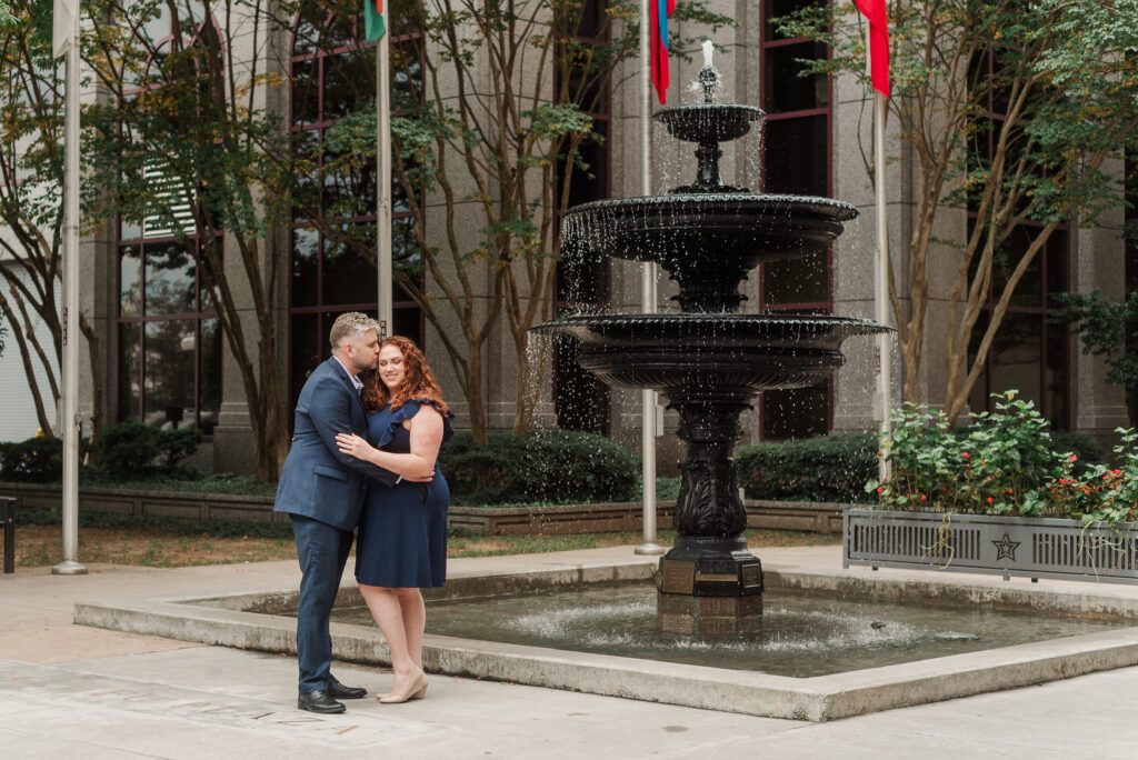 engaged couple embracing at fountain downtown Roanoke Virginia