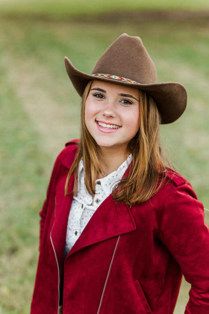 Senior portrait with red jacket and cowboy hat