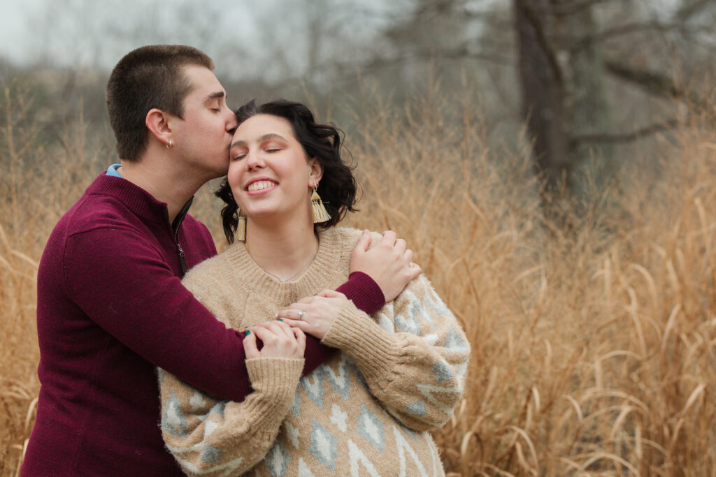 groom to be affectionately kissing bride to be