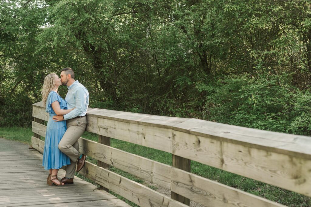 engagement session - couple on bridge kissing