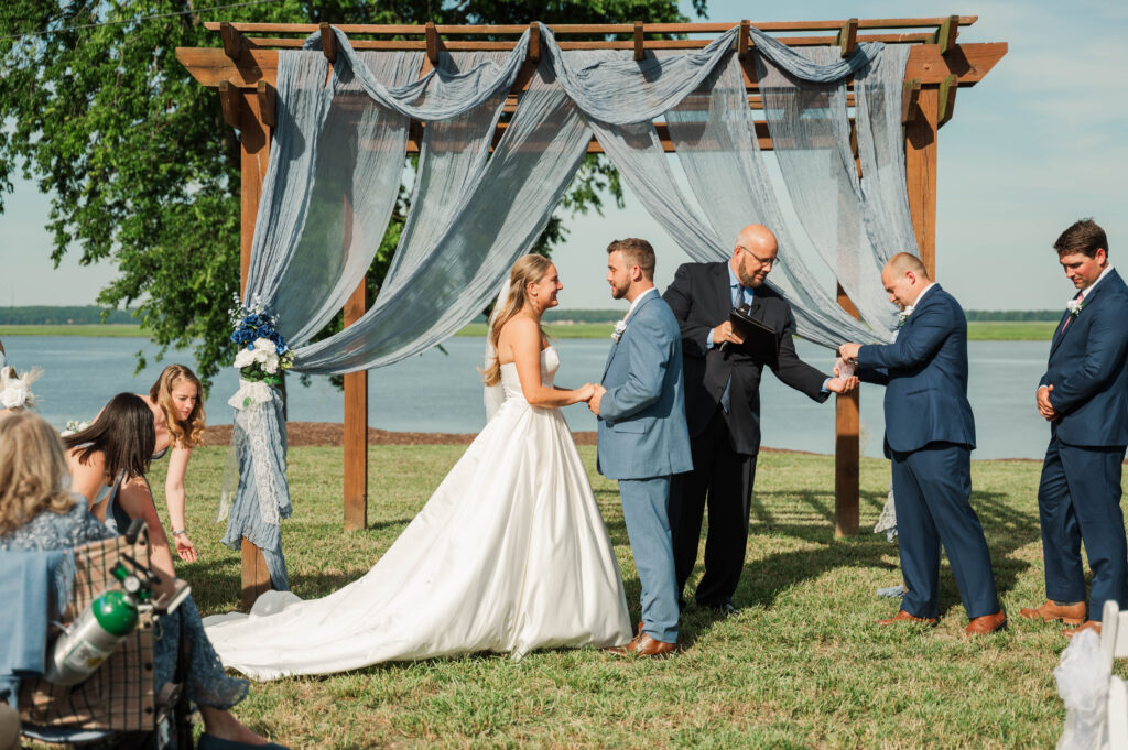 groomsmen handing rings to pastor