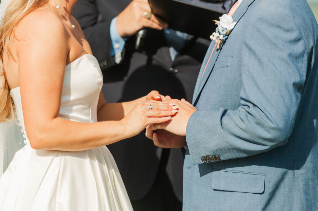 bride putting ring on groom