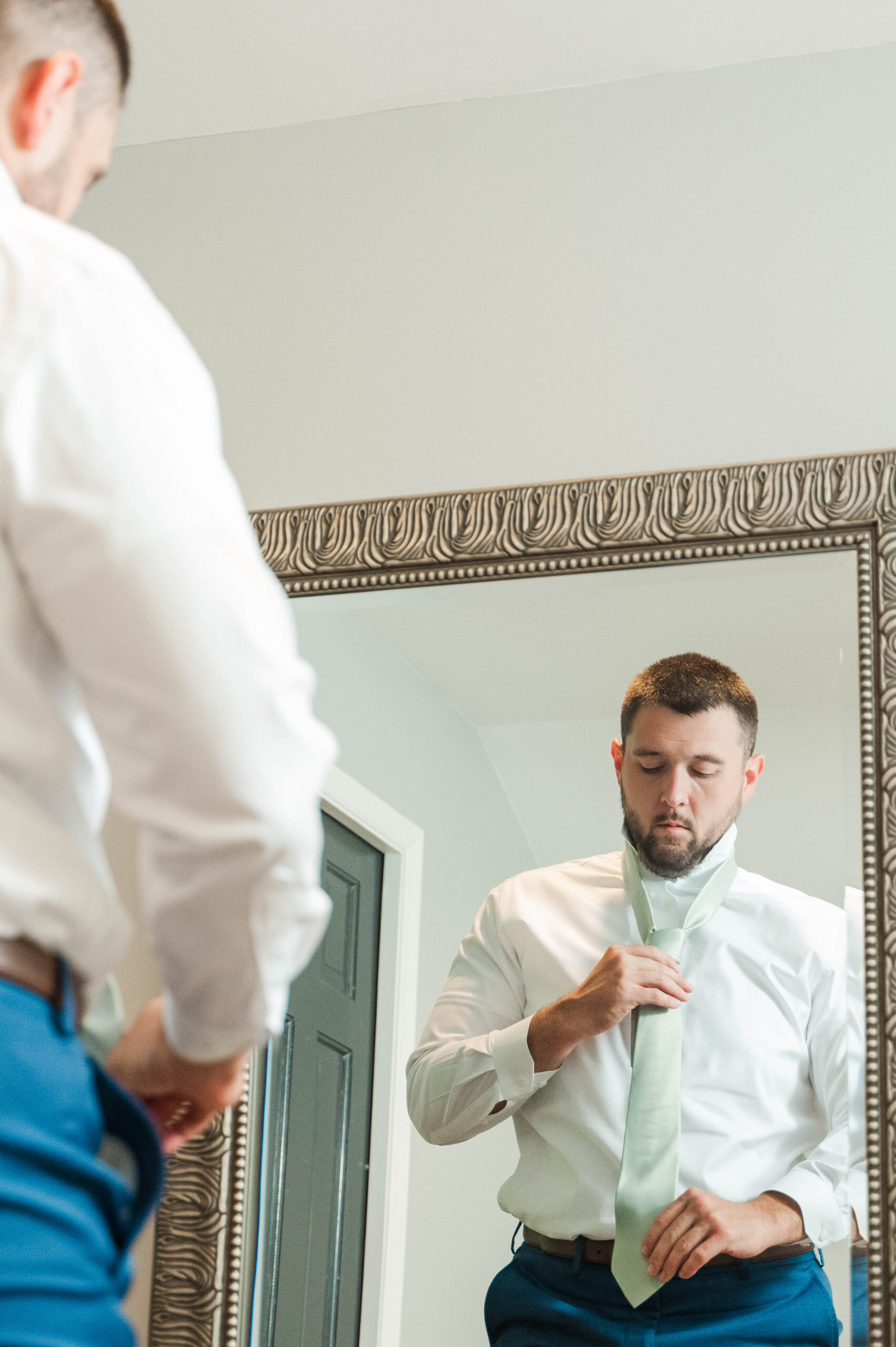 Groom putting on tie