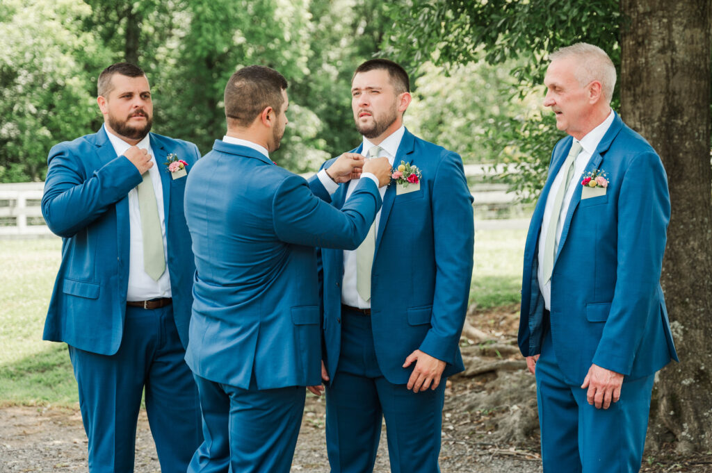 Groomsmen helping groom get ready 