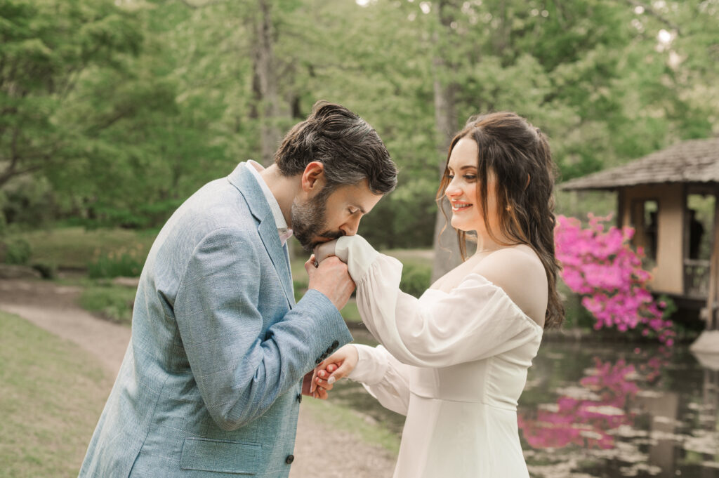 groom kissing bride's hand during engagement session