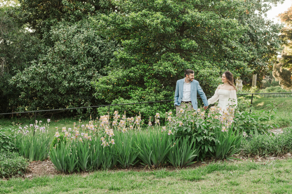 couple walking behind garden of irises