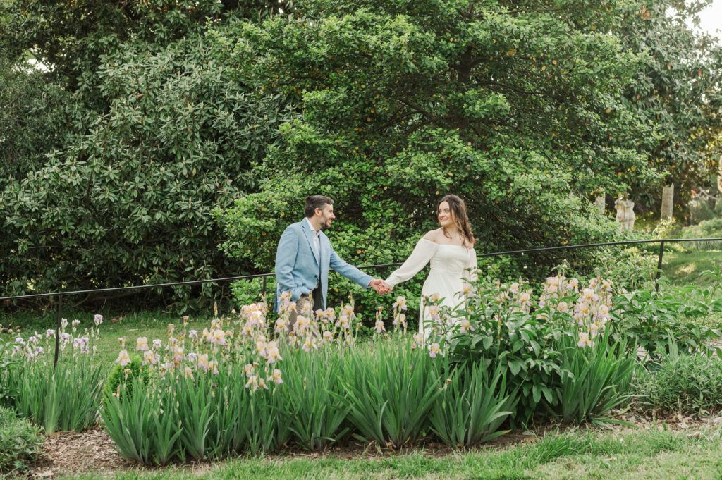 couple walking behind iris garden
