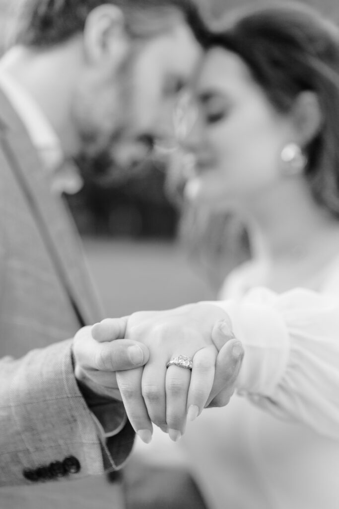 couple holding hands displaying engagement ring