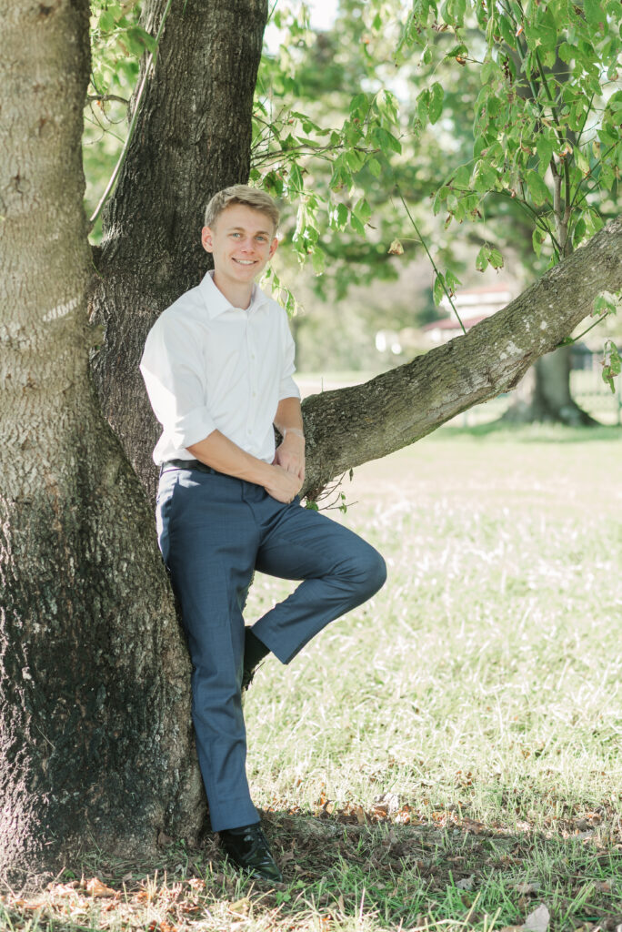 senior standiing by tree