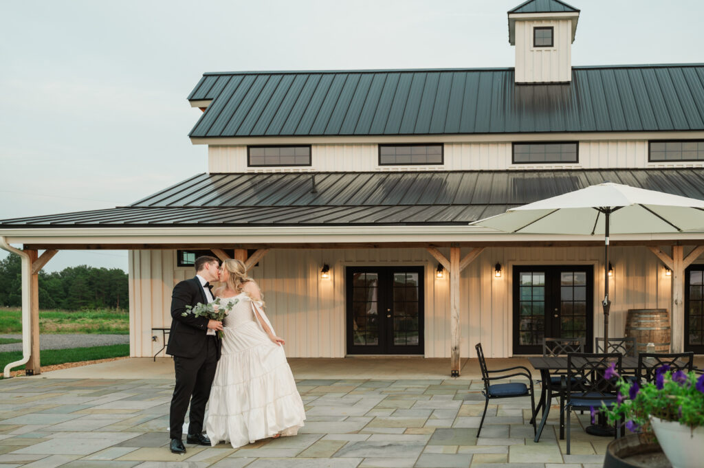 couple kissing in front of Blossom Ridge Farm & Vineyard